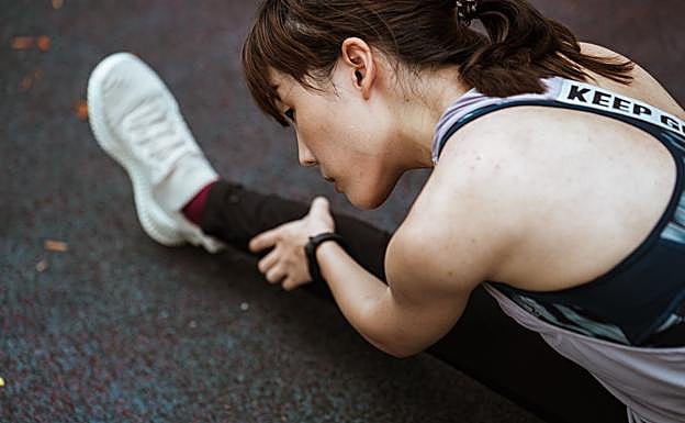 Mujer realizando estiramientos. /