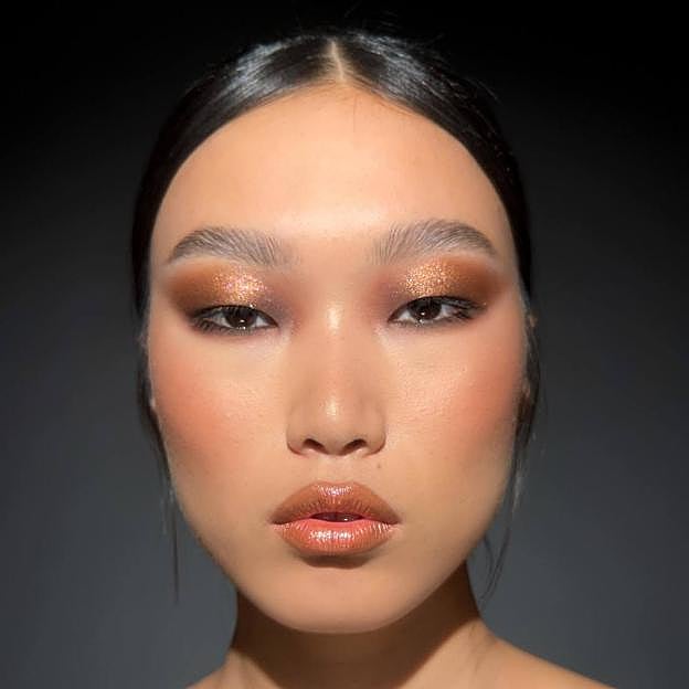 Modelo con maquillaje glitter bronceado