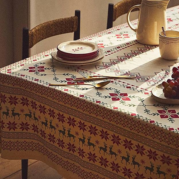 Imagen principal - El mantel de Navidad está disponible a partir de 25.99 euros, el pack de dos servilletas a juego cuestan 7.99 euros; la cristalería cuesta a partir de 5.99 euros la pieza y las cucharillas con motivos navideños, 19.99 euros el pack de 4.