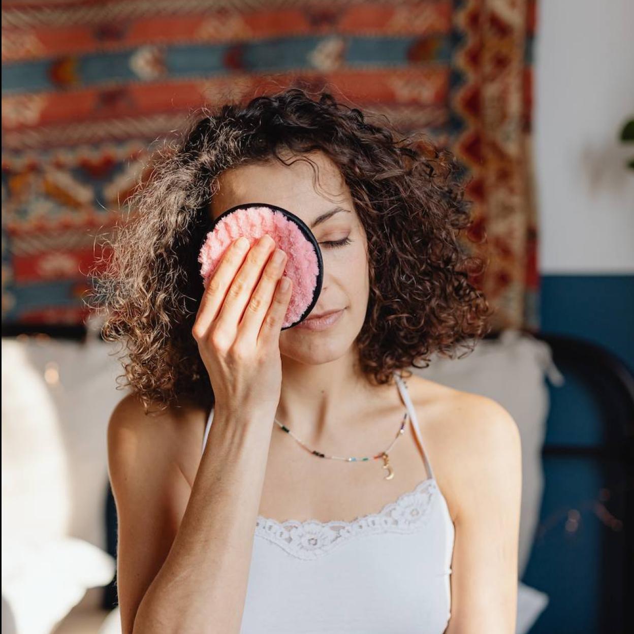 Mujer usando un disco desmaquillante reutilizable