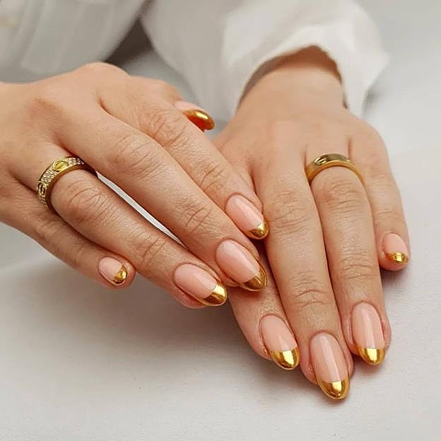 Uñas en tonos dorados estilo manicura francesa