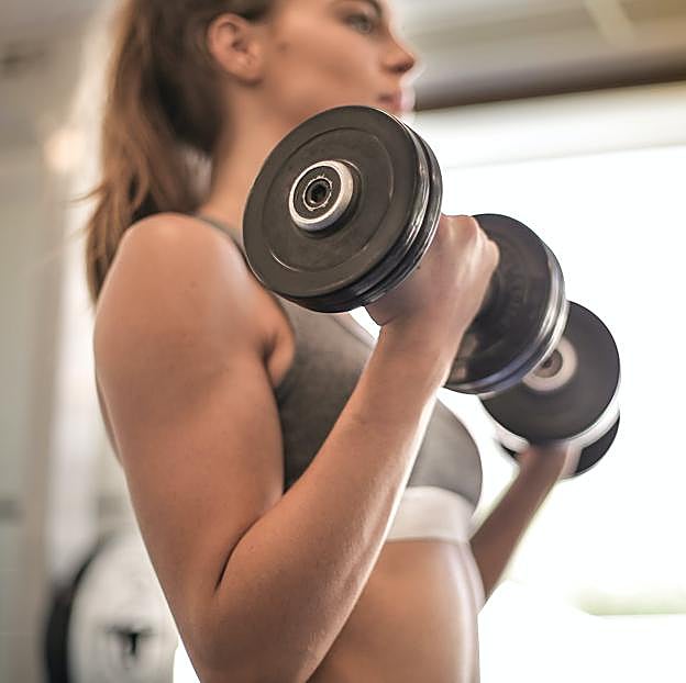 Mujer haciendo pesas en un gimnasio.