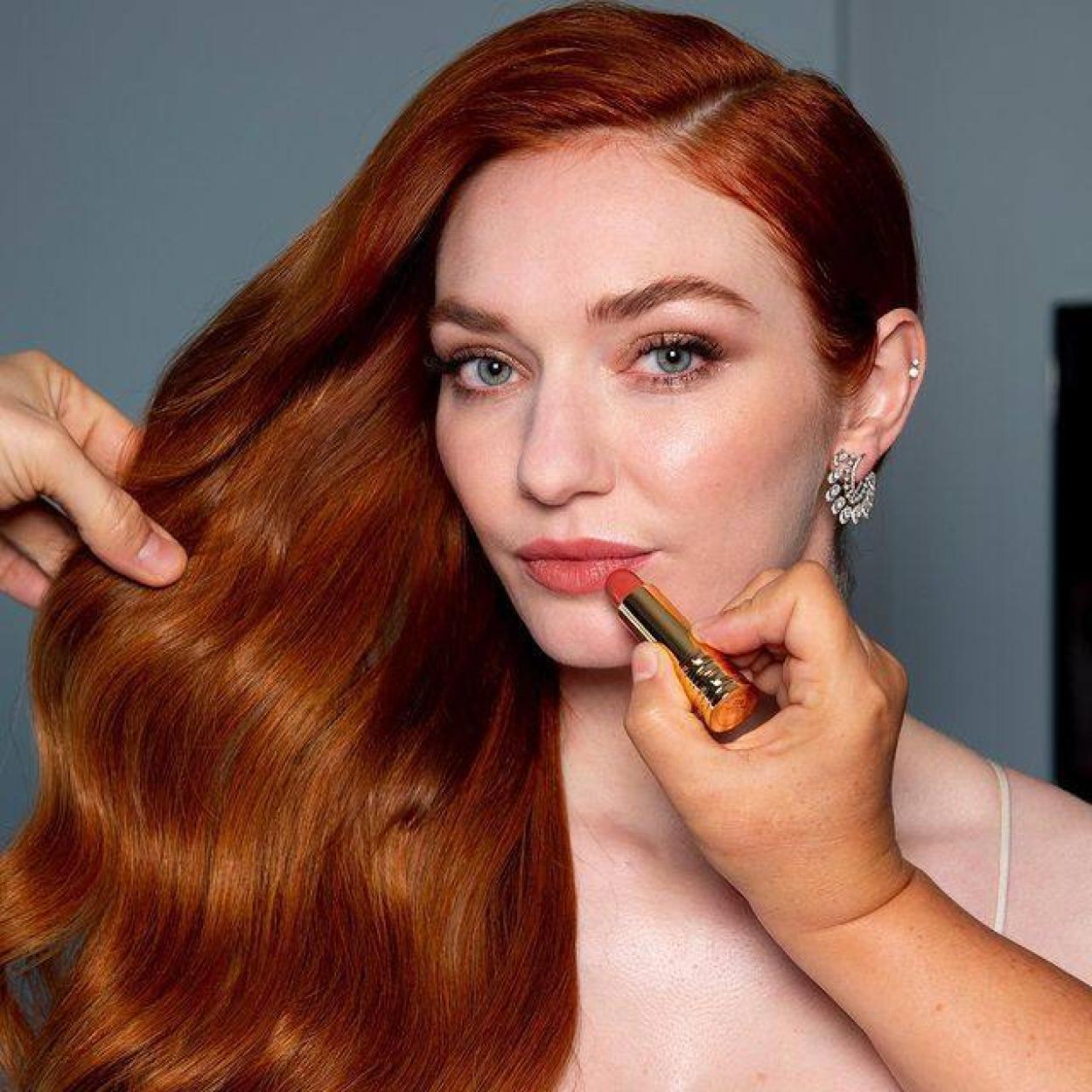 Maquillador profesional pintando labios a la actriz Eleanor Tomlinson