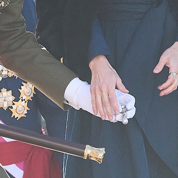 Imagen principal - El rey Felipe recoge el broche de la reina Letizia.