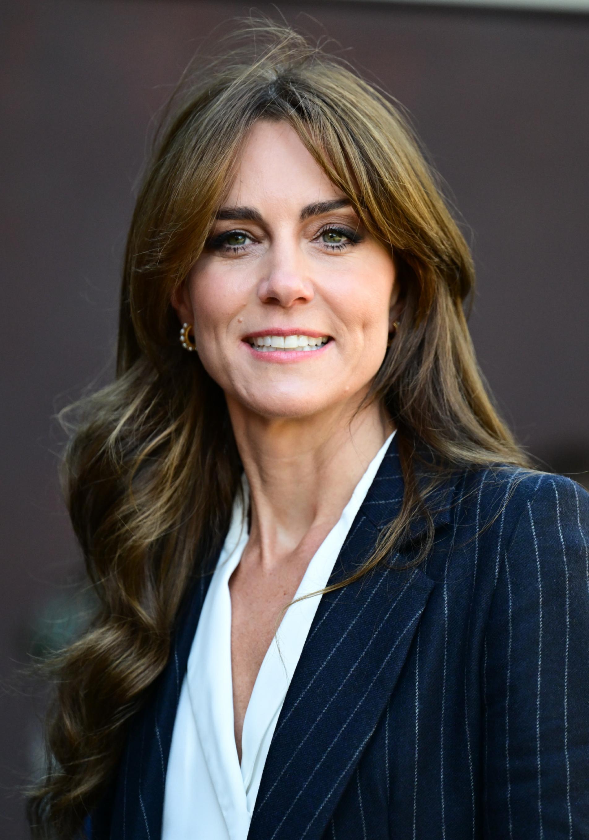 Kate Middleton con traje de raya diplomática y blusa blanca.