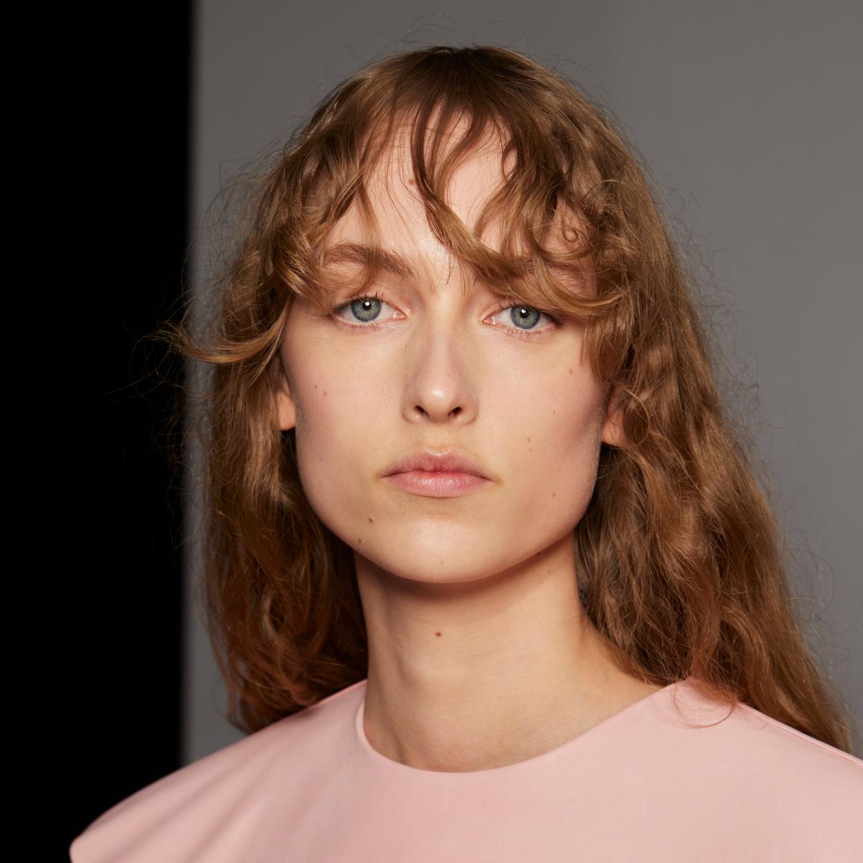 Una modelo con el pelo rizado.