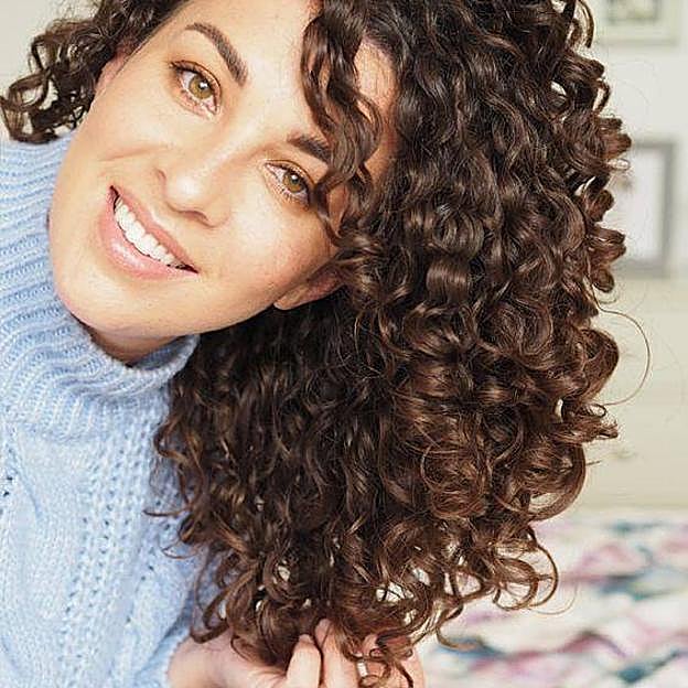 Mujer haciendo pulsing con pelo rizado