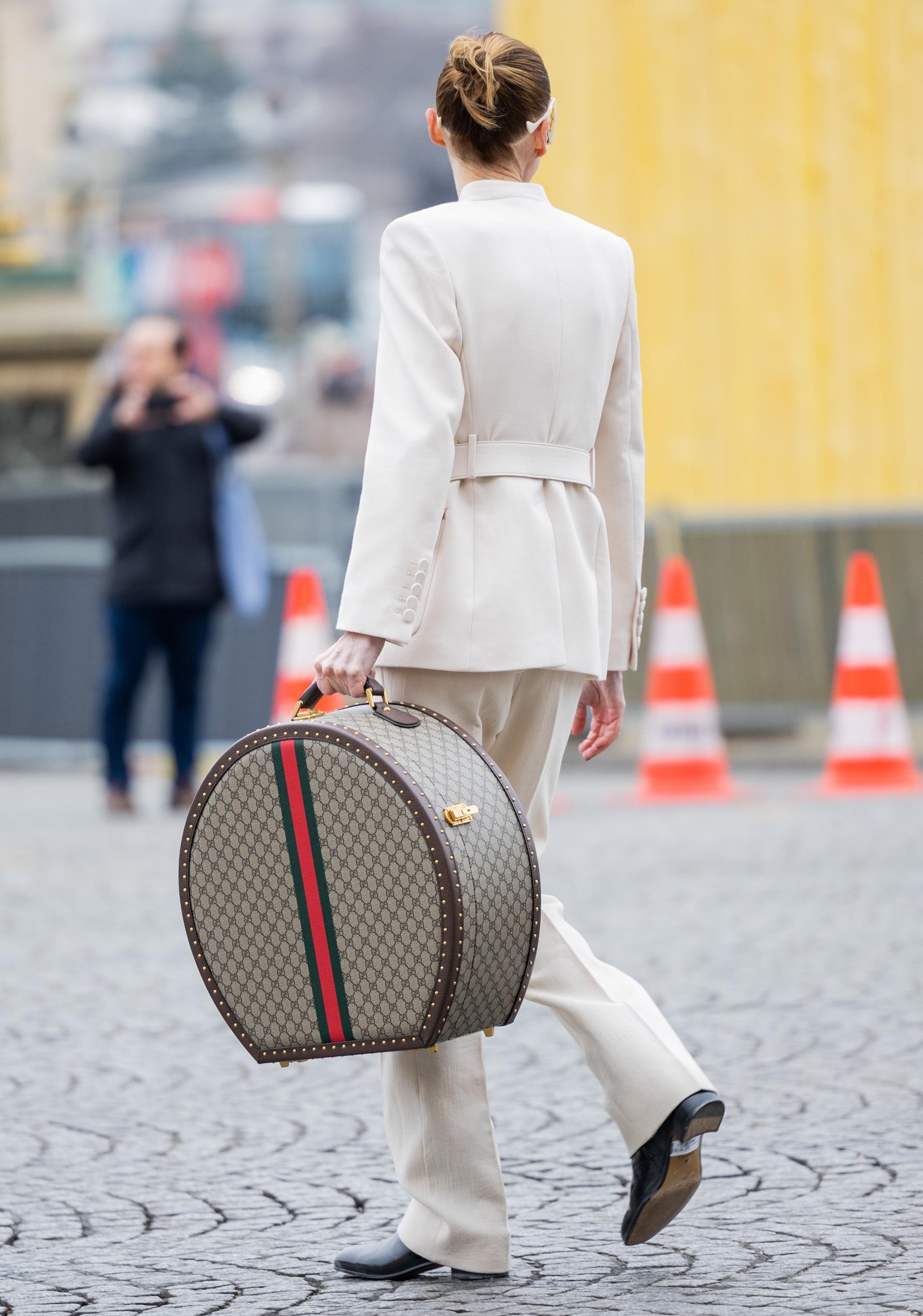 Invitada a la Semana de la Moda de París con maleta retro de Gucci.