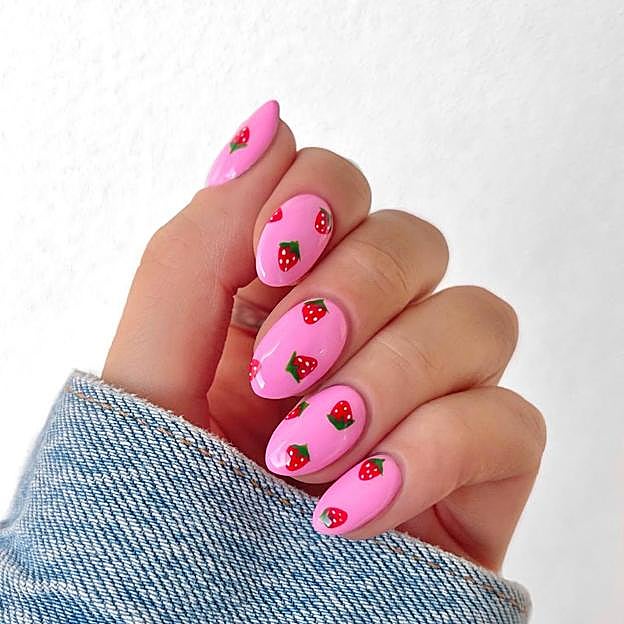 Manicura color rosa con dibujos de fresas