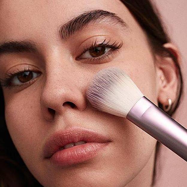 Modelo aplicando protector solar en polvo