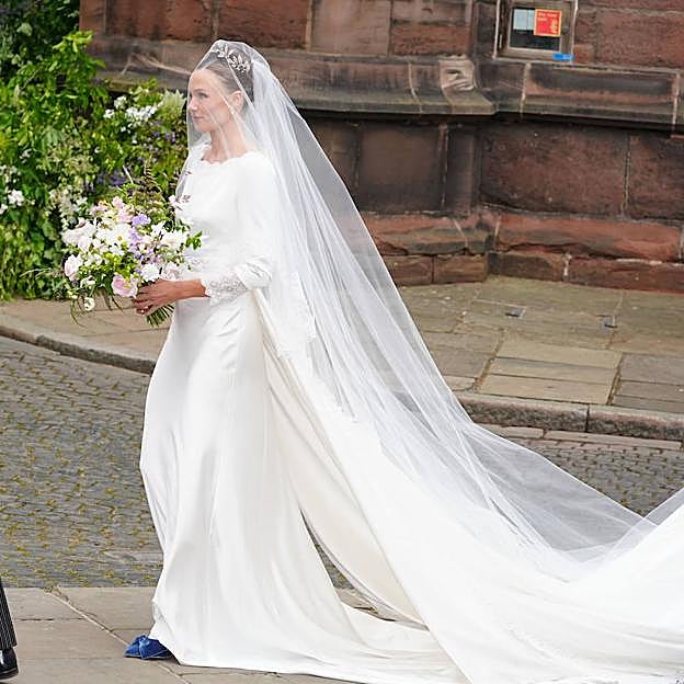 Olivia Henson completó el look de novia con unso zapatos de color azul.