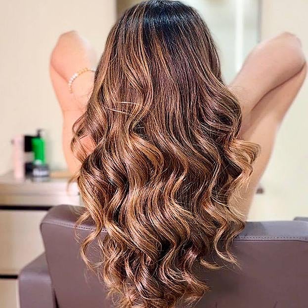 Mujer con mechas caramelo en peluquería Roho Hair Club