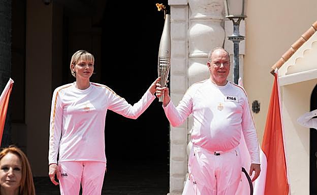 Los príncipes Alberto y Charlène de Mónaco portando la antorcha olímpica. 
