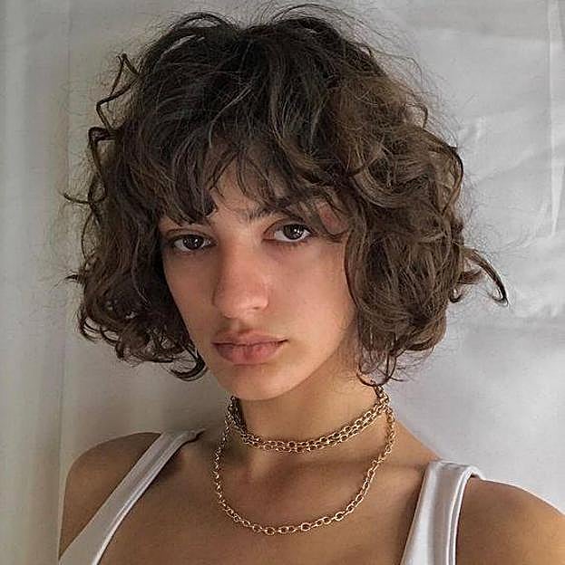 Modelo con corte de pelo rizado estilo bob francés