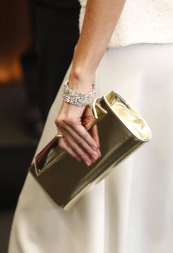 Imagen secundaria 2 - La reina Letizia combinó el vestido con complementos dorados y joyas de pasar.