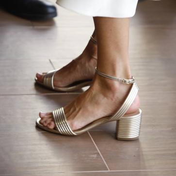 Imagen secundaria 1 - La reina Letizia combinó el vestido con complementos dorados y joyas de pasar.