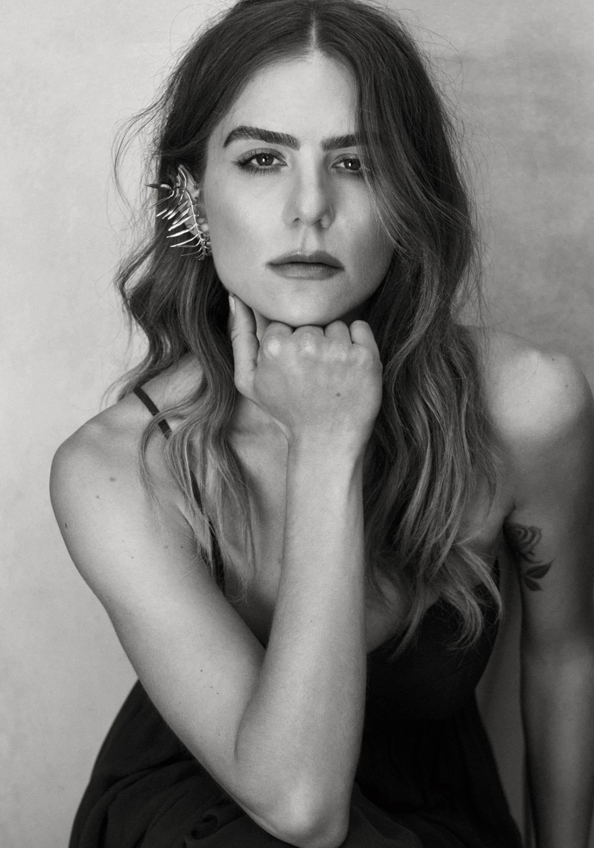 Morgane Polanski lleva vestido evasé de tirantes, de Pronovias; y pendiente de Sumacruz.