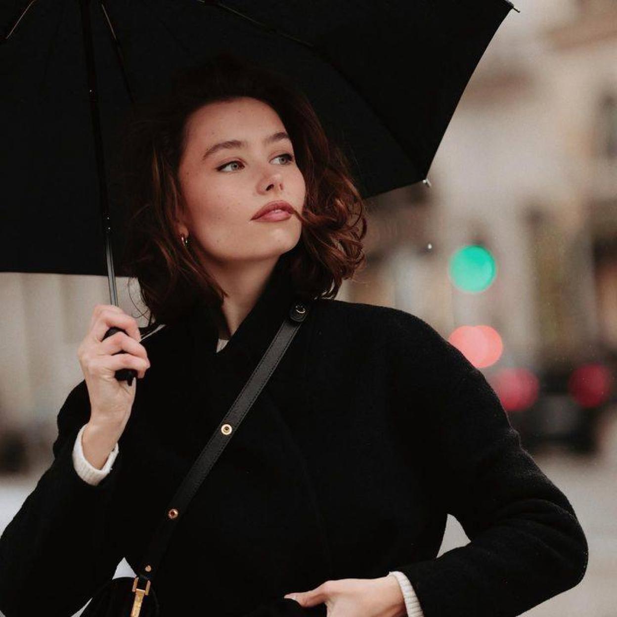 Influencer con paraguas en día lluvioso