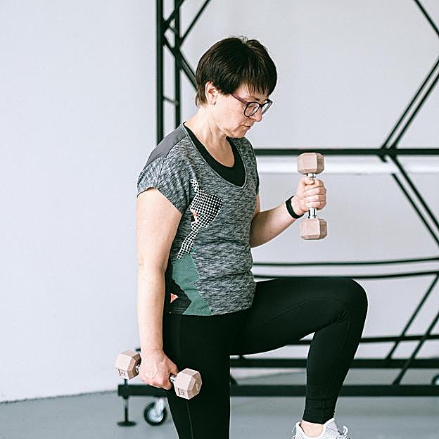 Mujer haciendo ejercicio con mancuernas. 
