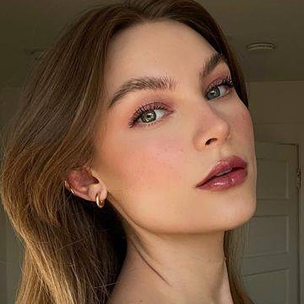 Influencer con la tendencia berry makeup en un total look burdeos