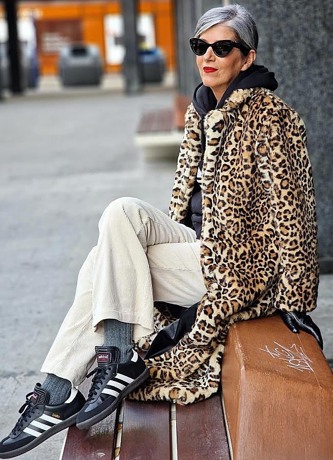 Carmen Gimeno in a leopard coat, black hoodie, cream pants and sneakers.