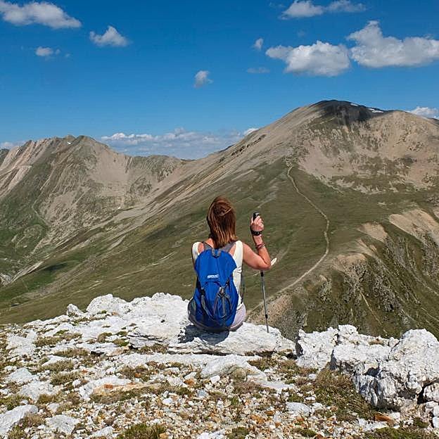 Mujer haciendo nordic walk en la montaña. 