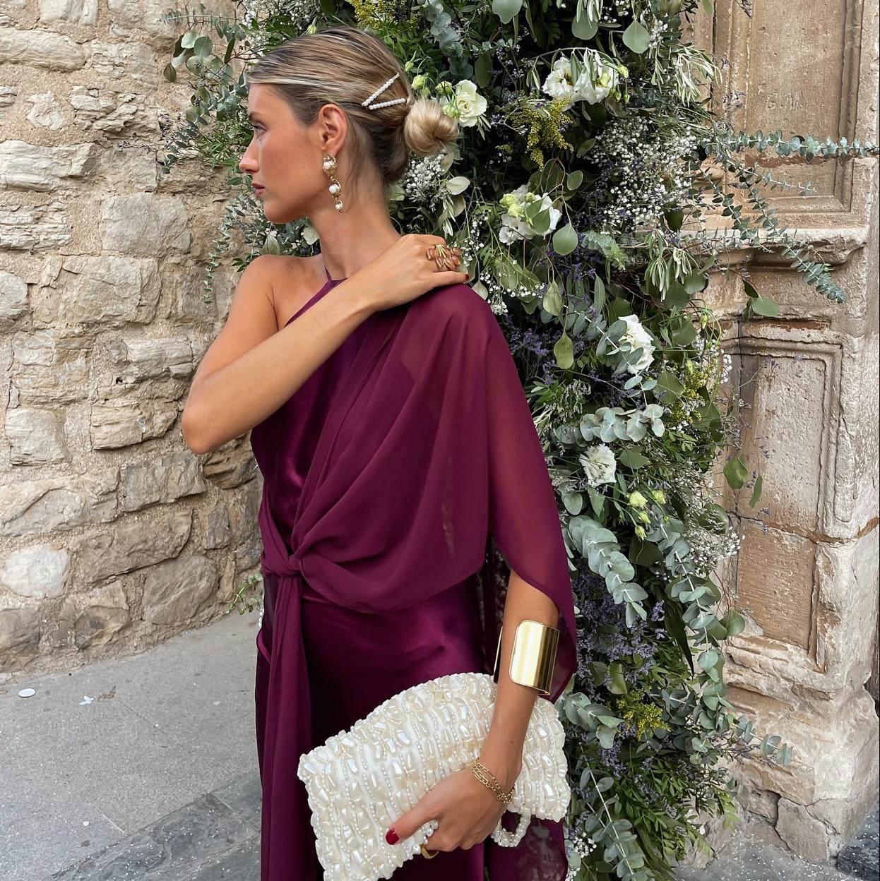 Una influencer con un look de invitada burdeos.