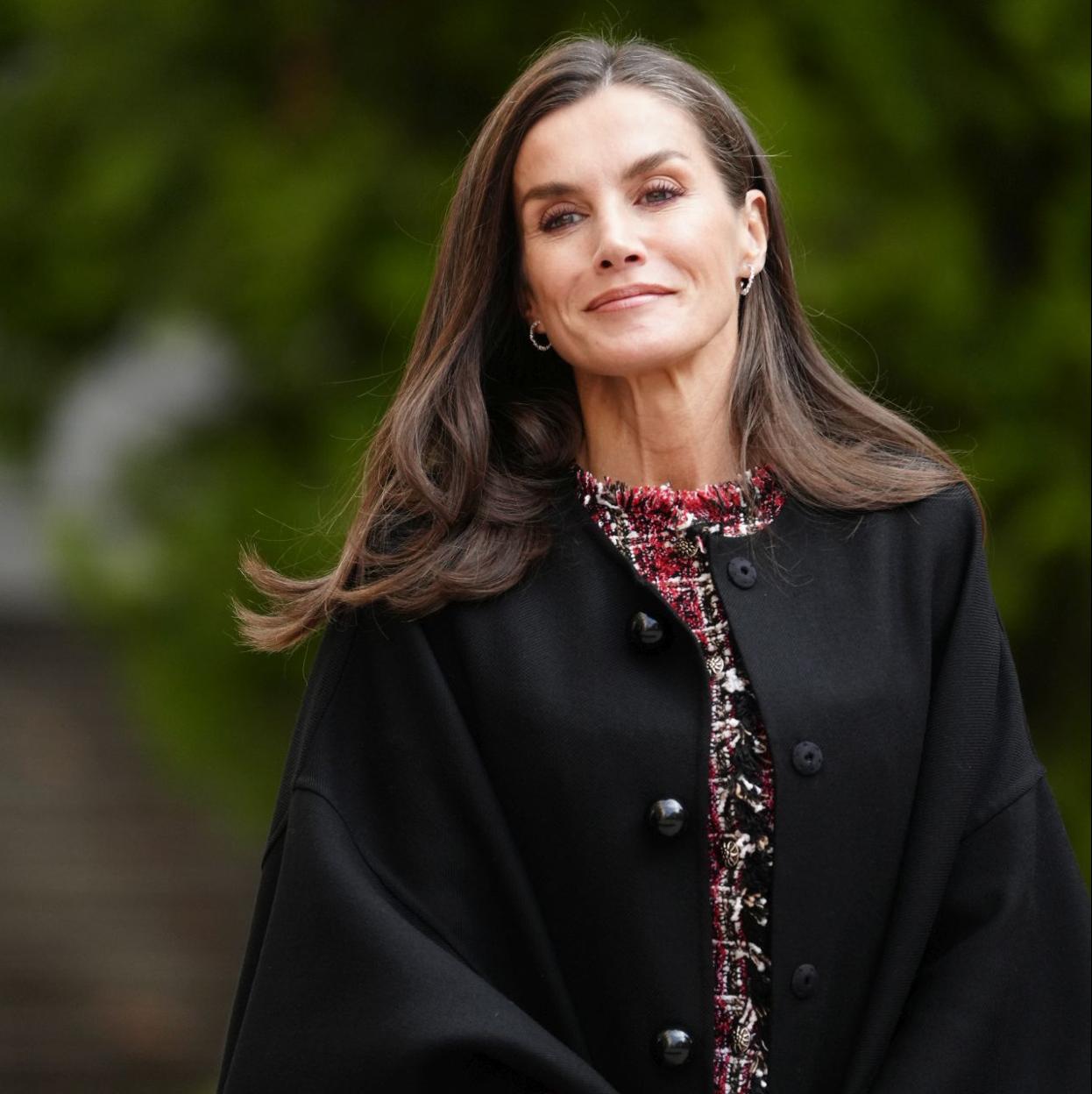 La reina Letizia con un abrigo capa de color negro.