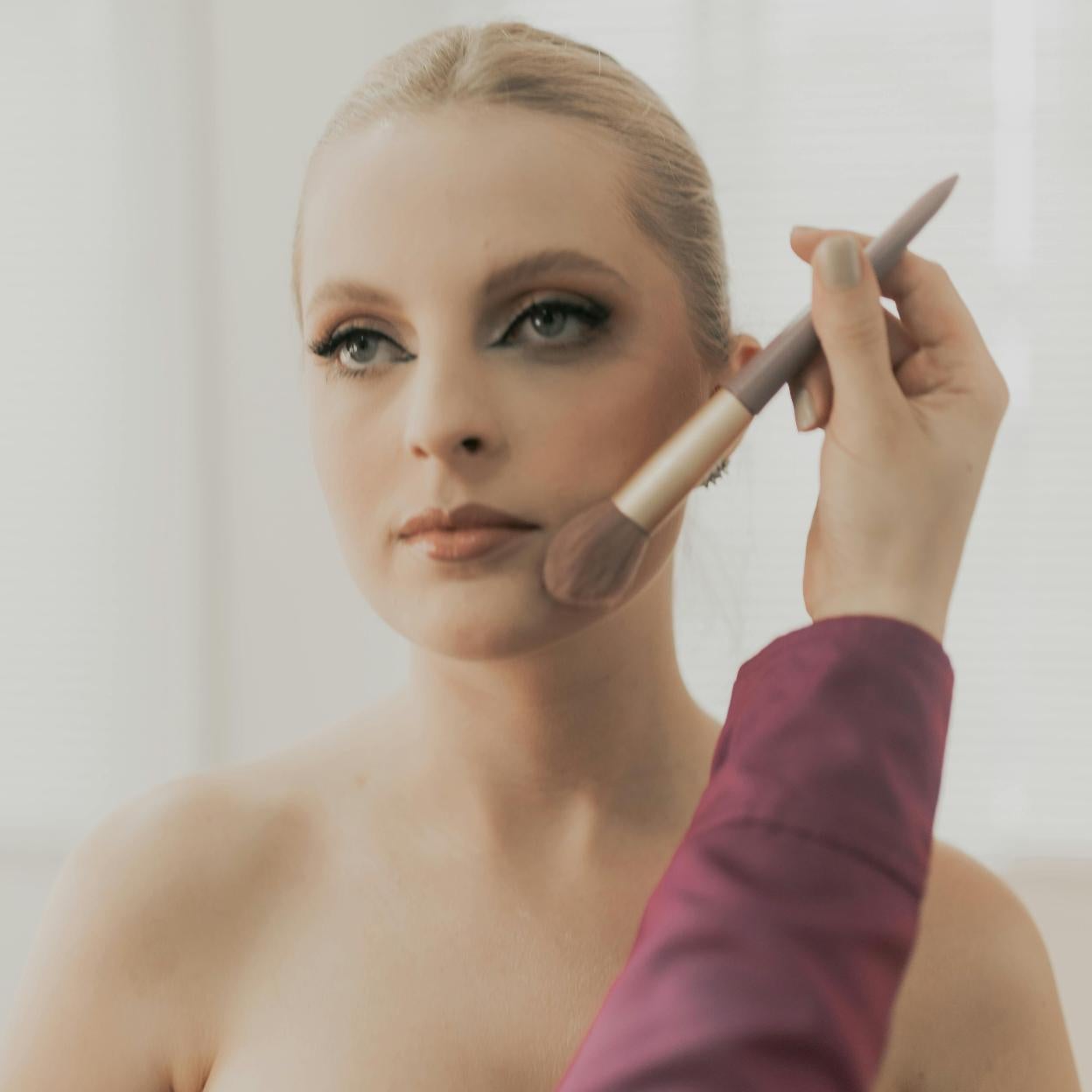 Maquilladora haciendo maquillaje a una influencer