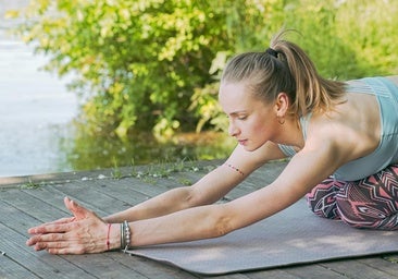 Mujer practicando yoga sobre esterilla.