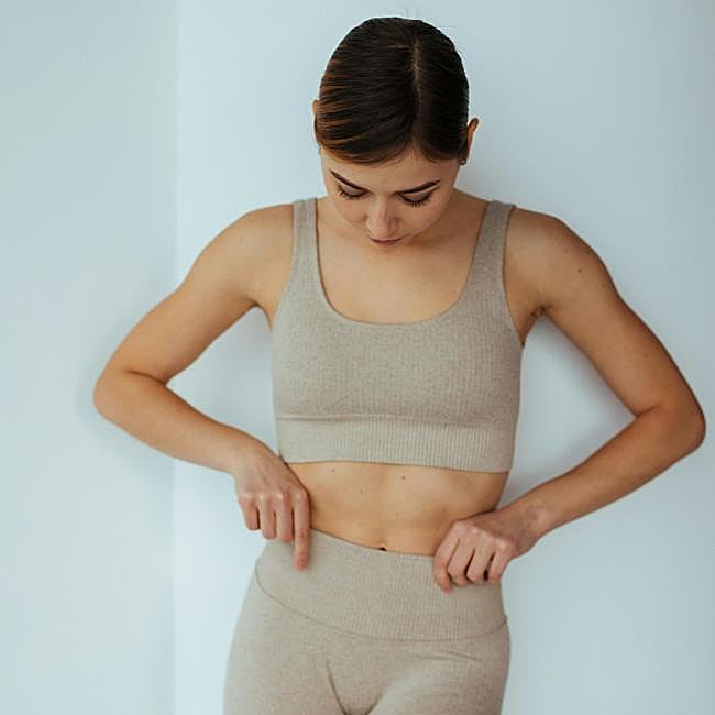 Mujer practicando yoga en casa.