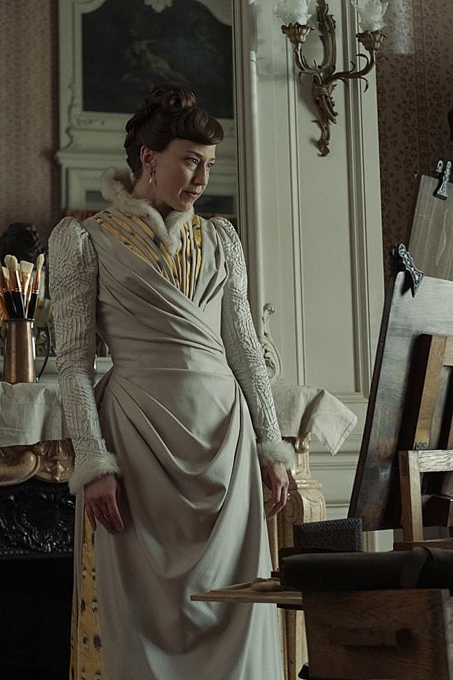 Carrie Coon como Bertha Russell, admirando el retrato que el pintor estadounidense le hace a su hija Gladys.