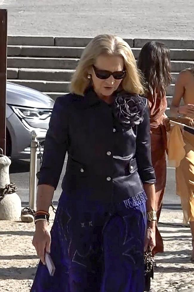 La infanta Elena completó el look con un abanico y gafas de sol.
