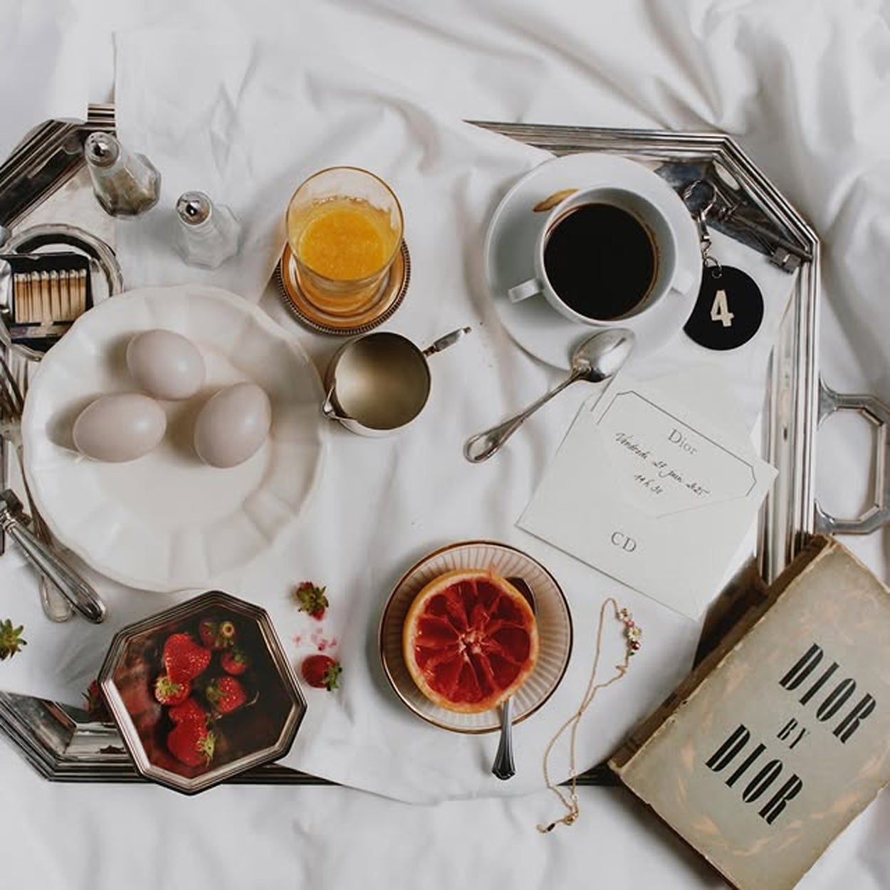 Los platos blancos con los tres huevos de cerámica con los que llegaba la invitación de Jonathan Anderson para su debut con Dior en París.