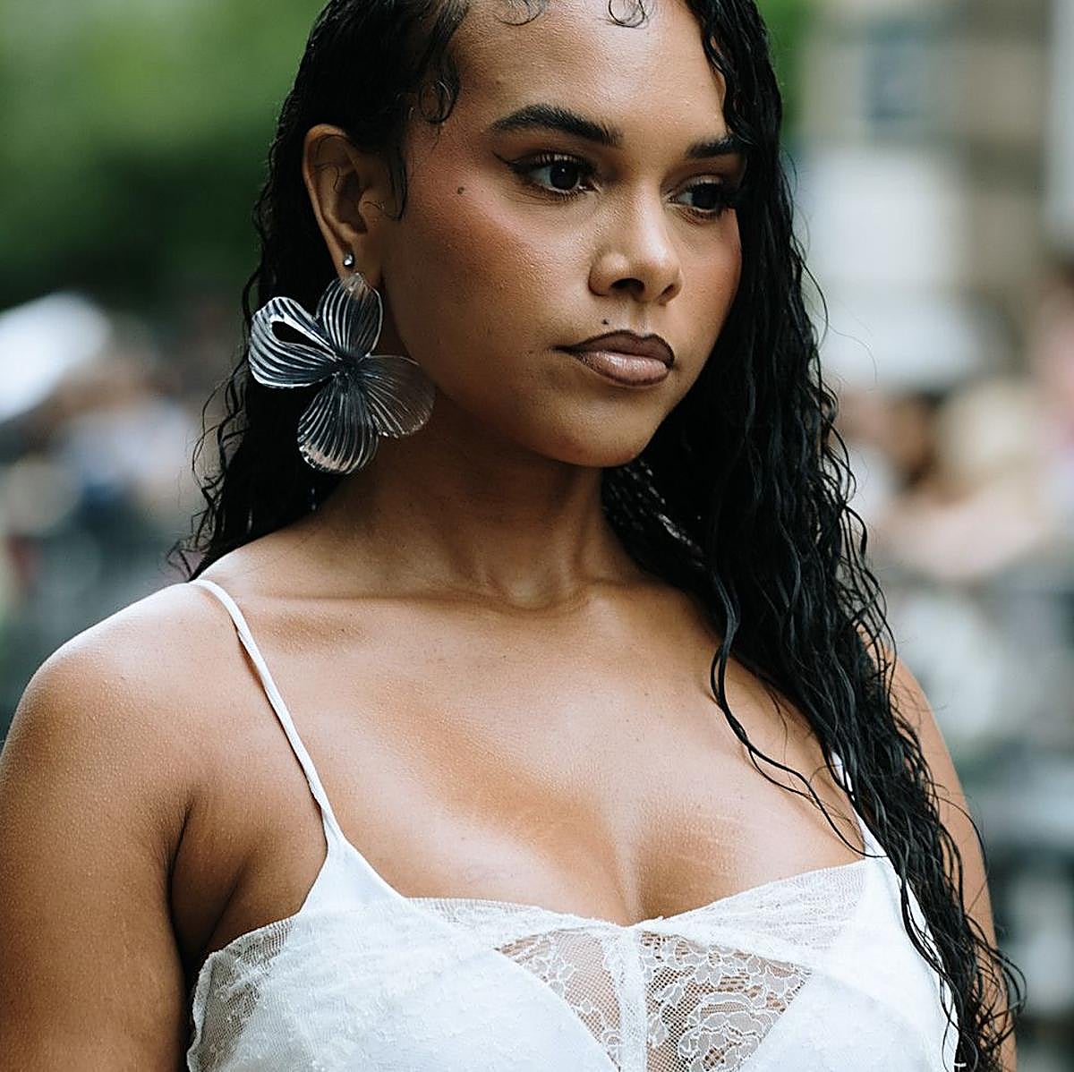 Una modelo con pendientes en forma de flor.