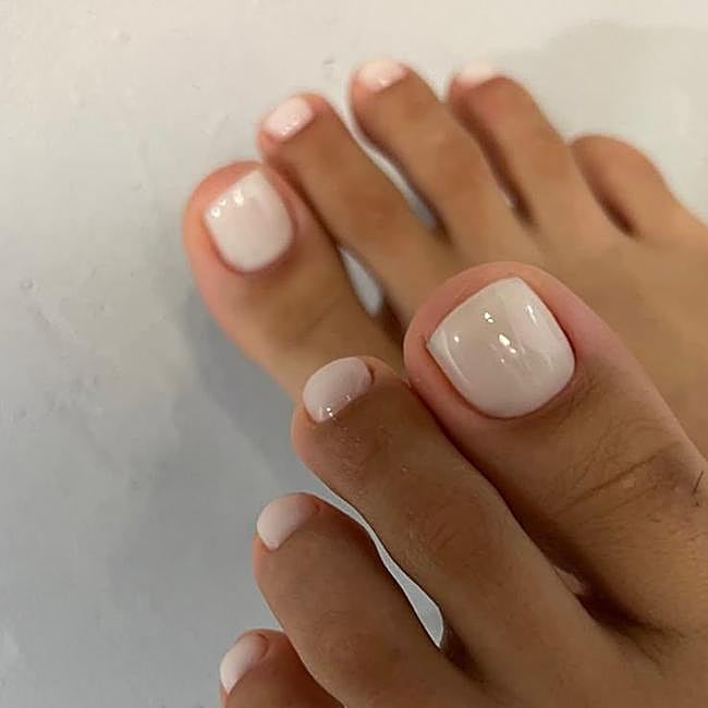 Pedicura con esmalte blanco lechoso
