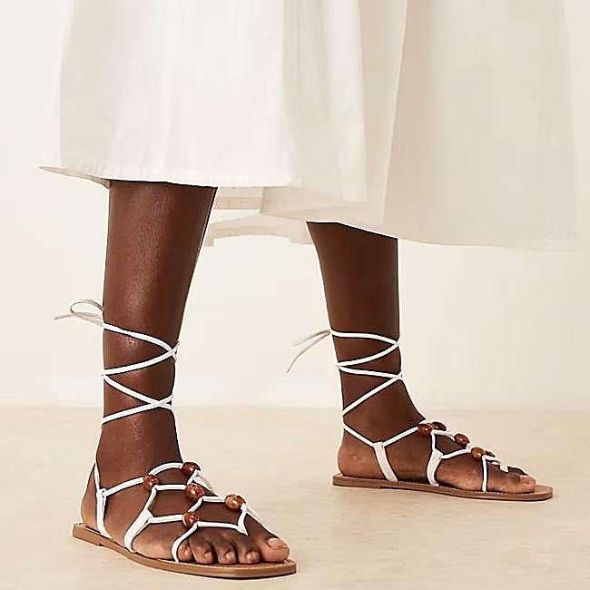 Sandalias blancas atadas con cuentas