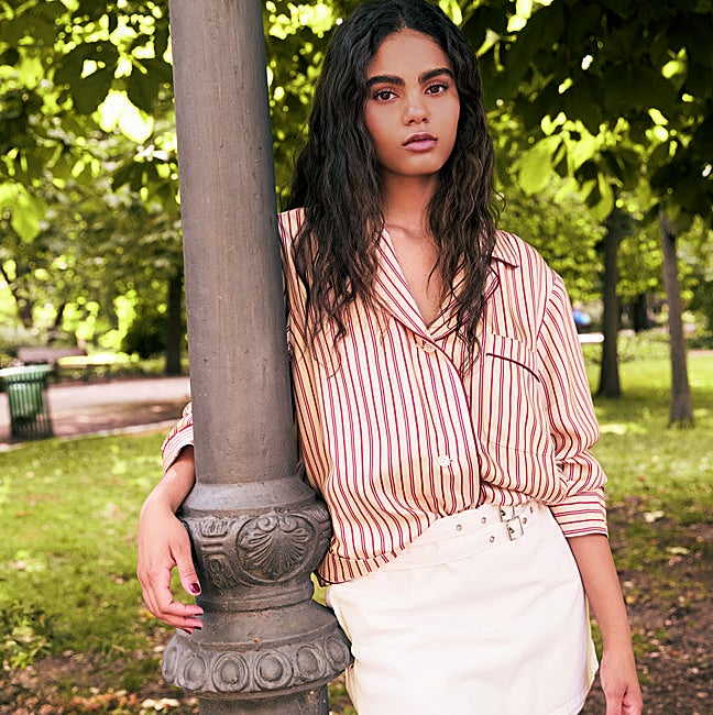 Camisa de seda, de Louis Vuitton; y falda mini con doble cinturón, de Mango.