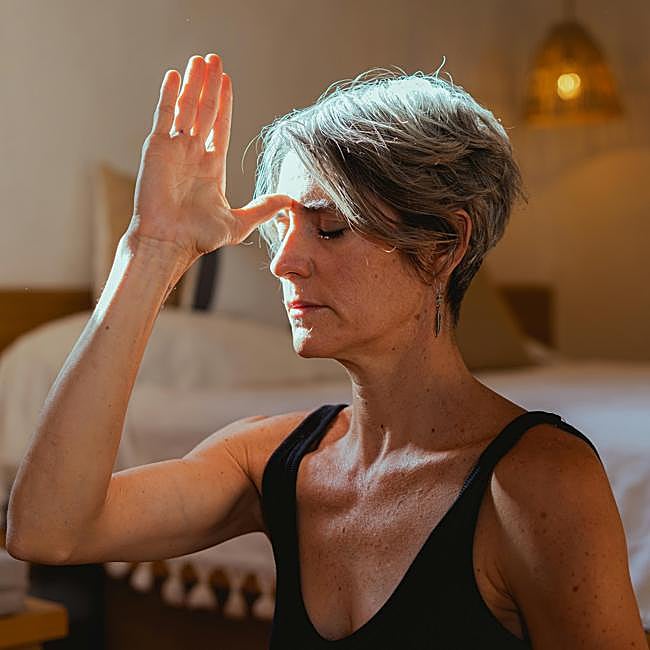 Mujer practicando yoga en casa.