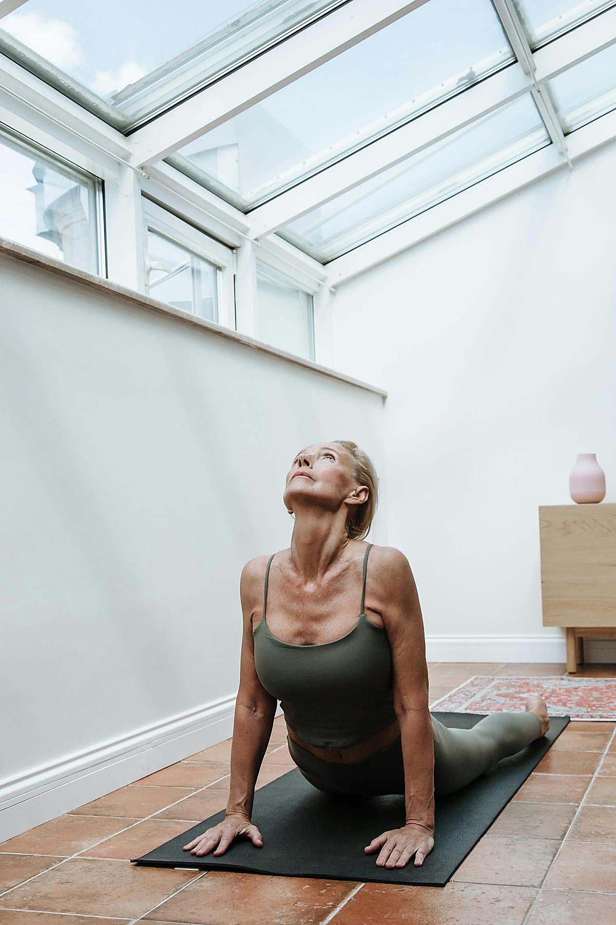 Mujer practicando yoga en casa.