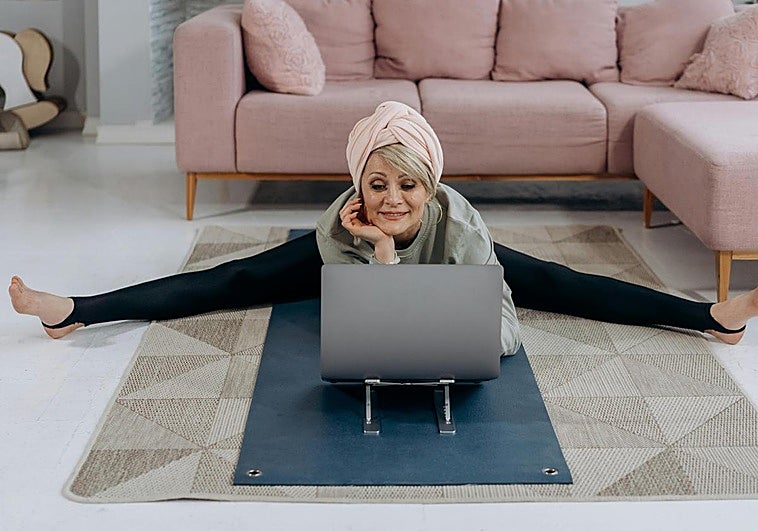 Mujer practicando yoga en casa.