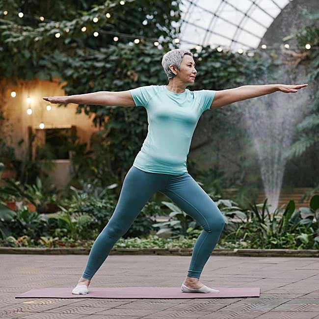 Mujer practicando yoga al aire libre.