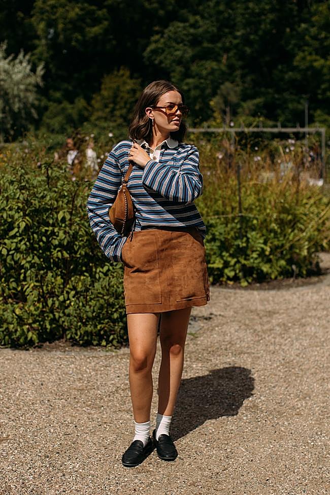 Un look con piezas de falda de ante, polo de rayas y bolso boho de ante.