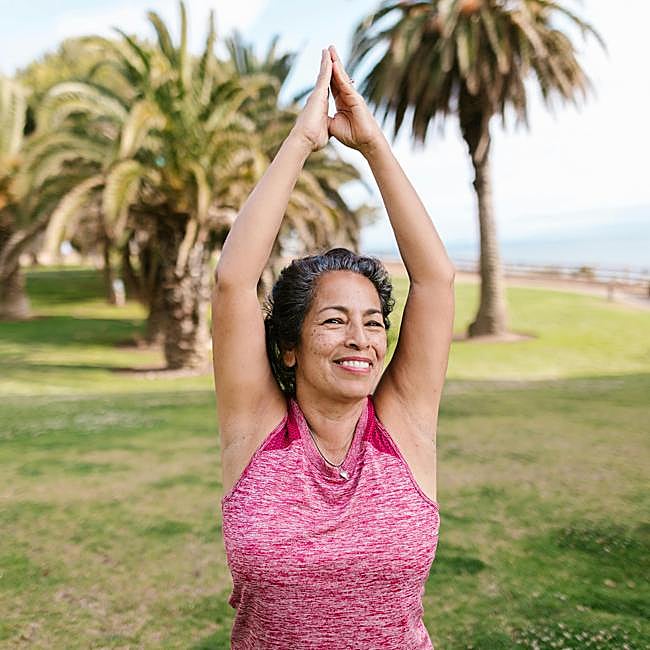 Mujer meditando al aire libre.