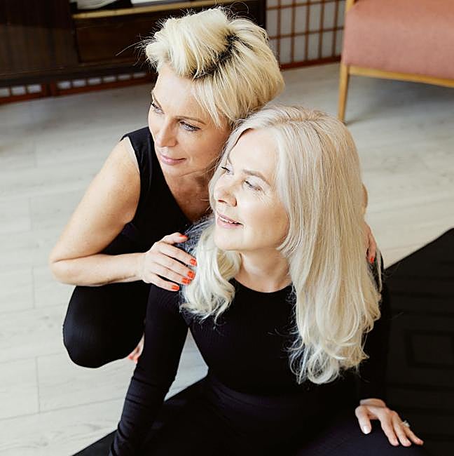 Mujeres practicando yoga en esterilla.