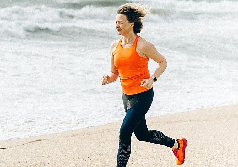 Mujer corriendo por la playa.