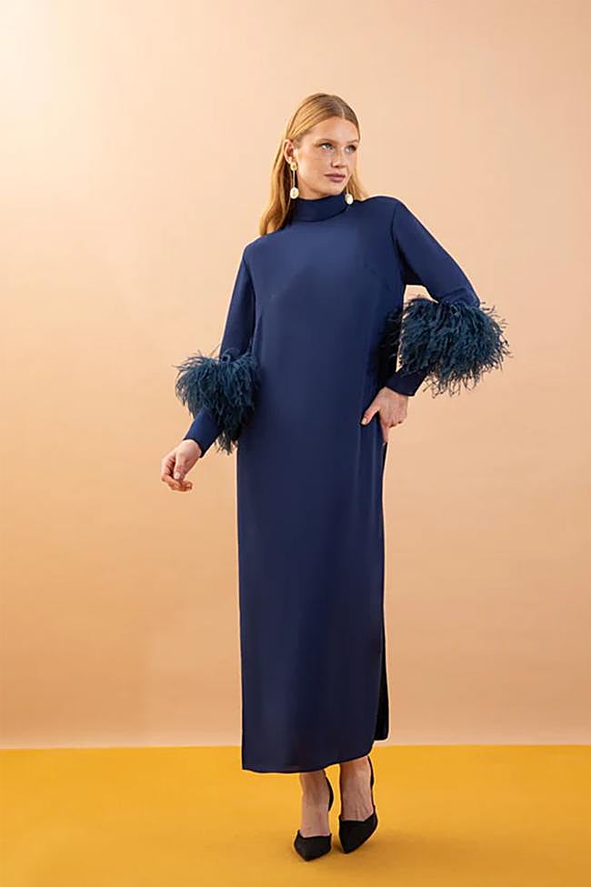 Vestido estilo caftán con detalle de plumas en las mangas de Victoria.