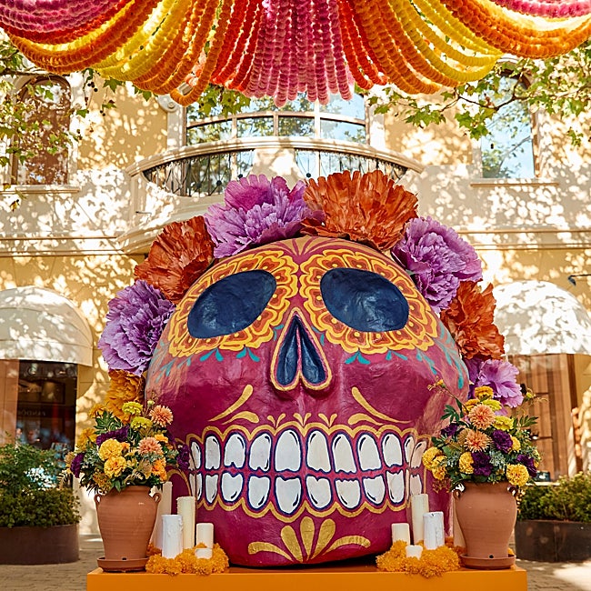 Un altar con la calavera, las velas y las flores en los bulevares de Las Rozas Village.