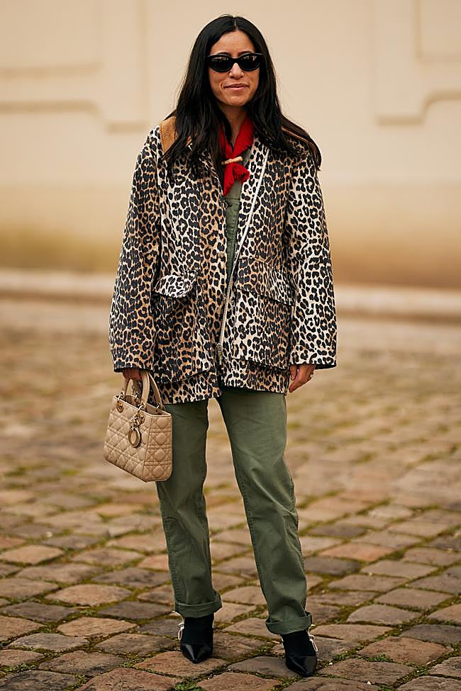 Abrigo de animal print con pantalones verdes.