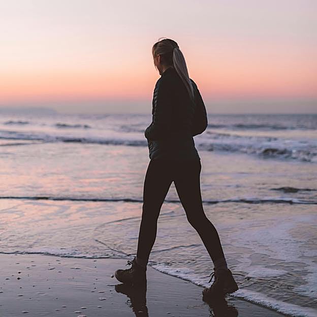 Mujer caminando por la playa. 